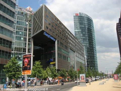 Potsdamer Platz in Berlin: glass towers, Sonny Liston billboard, people under cloudy sky
