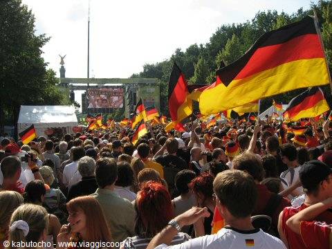 Crowd waving German flags near Berlin's Siegessäule during a public event
