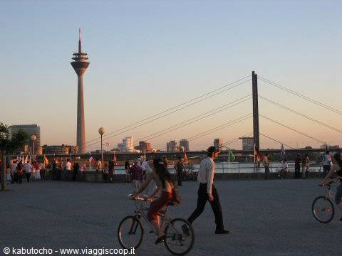 Cyclists and walkers along the Rhine promenade with the Rheinturm in Düsseldorf