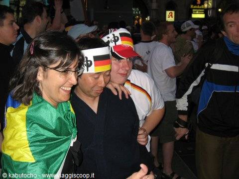 Germany and Brazil football fans celebrating together in a nighttime crowd