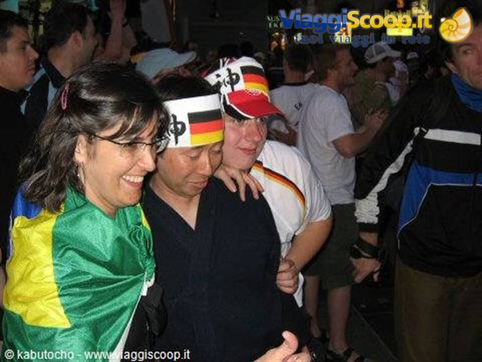 Germany and Brazil football fans celebrating together in a nighttime crowd