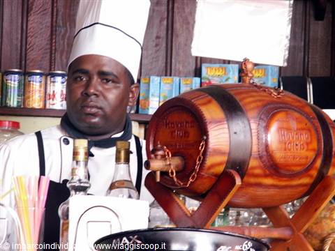 Chef in uniform beside a wooden Havana Club barrel and rum bottles