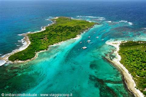 Green islets surrounded by turquoise water with anchored yachts, aerial shot