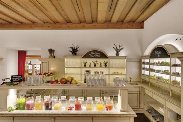 Fresh juice and fruit buffet under wooden ceiling, hotel interior