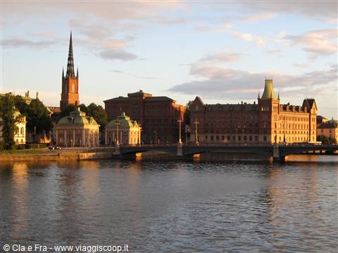 Riddarholmen church spire and brick buildings glowing in golden light, Stockholm