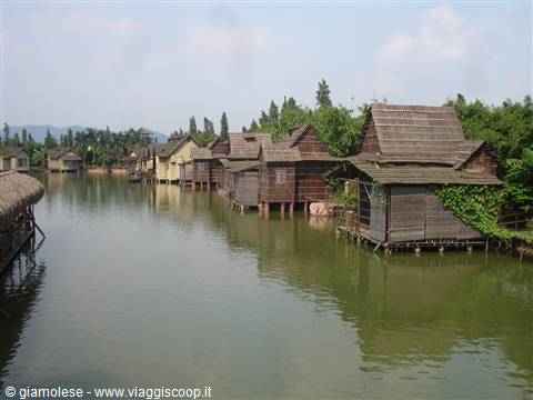 wooden stilt houses along the river with thatched roofs