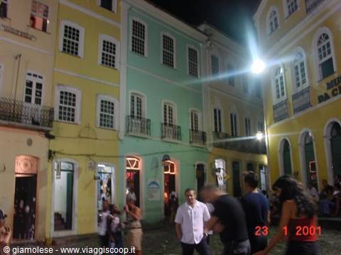 People walk at night among colorful colonial houses in Pelourinho, Salvador
