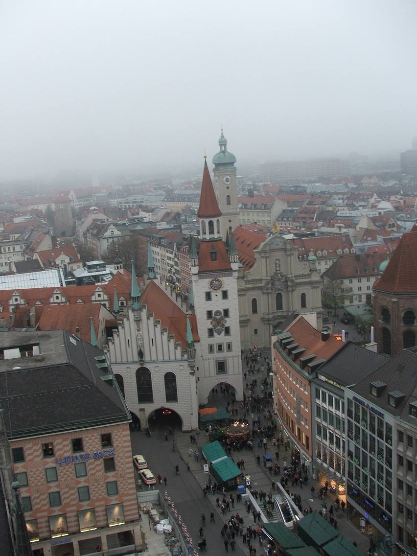L'Altes Rathaus di Monaco sotto la nebbia, tetti rossi e folla in Marienplatz