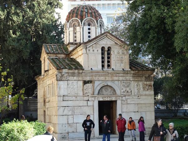 Tourists outside the small marble Byzantine church of Panagia Gorgoepikoos, Athens