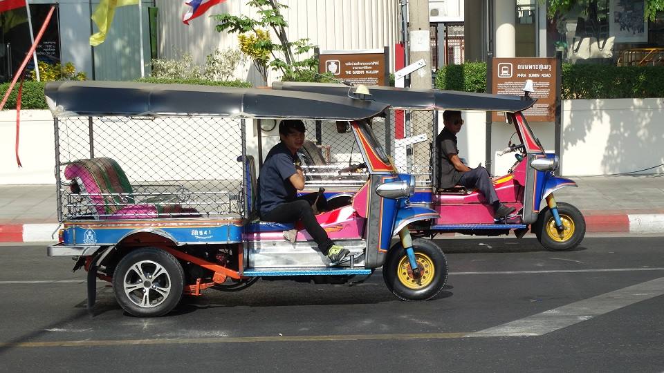 Due tuk-tuk colorati con guidatori in attesa sulla strada