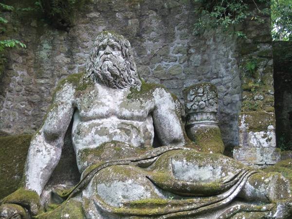 Moss-covered colossal Neptune statue at the Park of the Monsters, Bomarzo