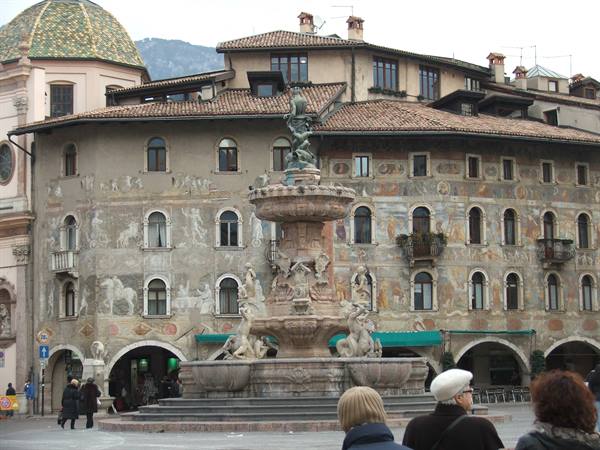 Neptune fountain in front of painted buildings on Duomo square, Trento