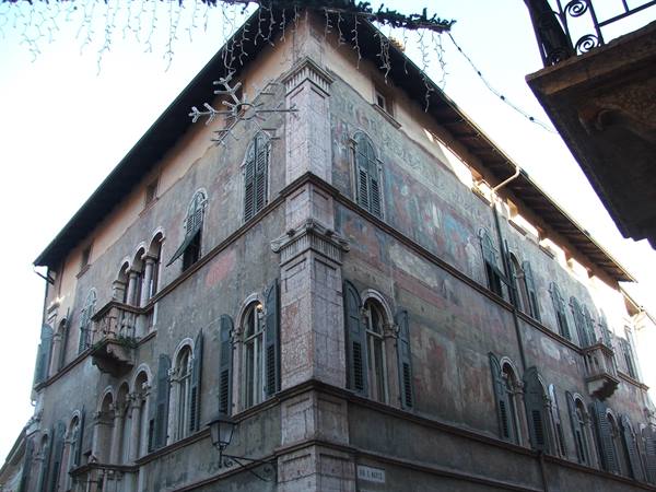 Frescoed corner palace with arched windows and Christmas decorations hanging above