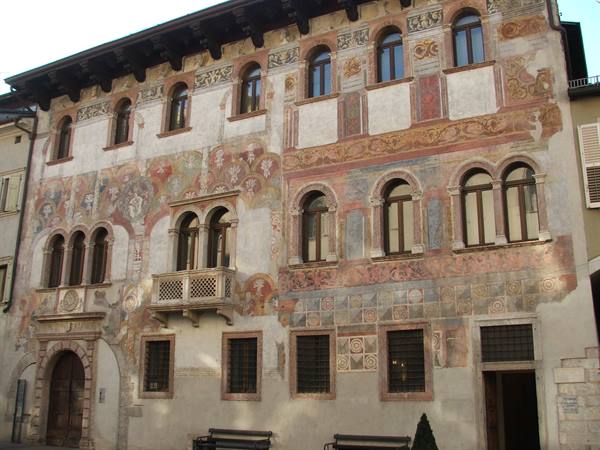 Renaissance building with frescoed facade and arched windows in Trento