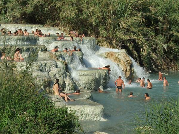 Bathers in the travertine thermal cascades of Saturnia