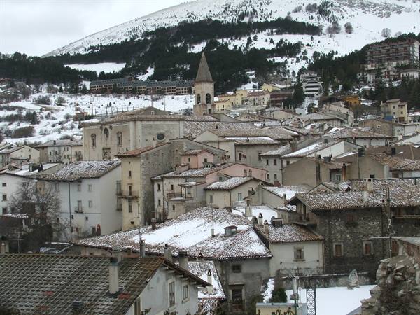 Snow-covered rooftops and bell tower in Opi village, snowy Abruzzo mountains