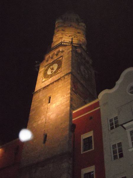 Innsbruck city tower illuminated at night with golden clock face
