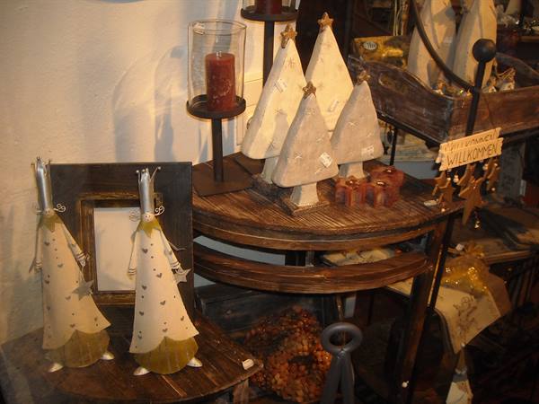 Christmas decorations in metal and wood on rustic table, red candle, Willkommen sign
