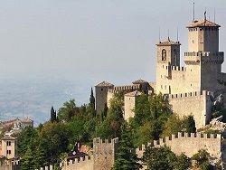 Rocca Guaita a San Marino, mura in pietra e torri sopra la nebbia