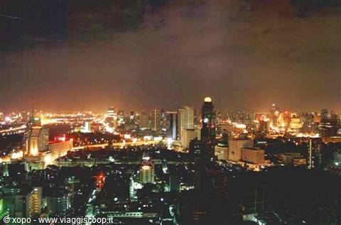 Illuminated skyscrapers at night over the city, yellow lights among buildings