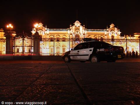 Police car in front of the illuminated Government Palace at night, Lima