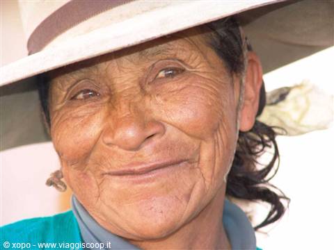 Portrait of elderly woman wearing straw hat, natural light, smiling