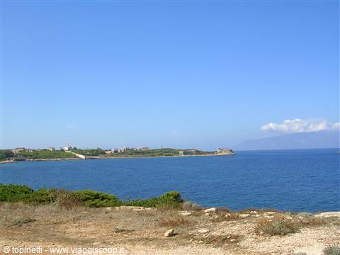 Blue bay facing a small village on a rocky coastline