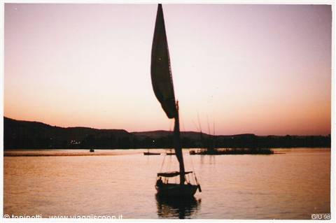 Sailboat with white sail on the Nile at Aswan, pink sky