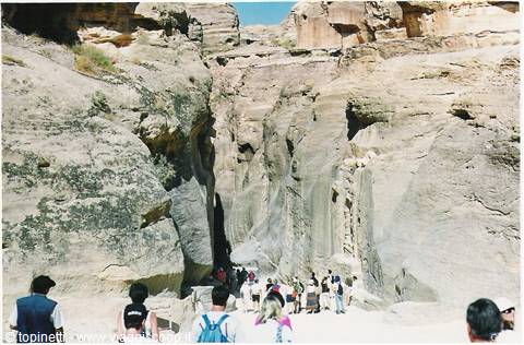 Tourists walk through the Siq, the rocky gorge leading to Petra