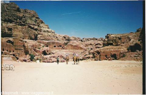 Horses on sand before the rock-cut tombs of Petra
