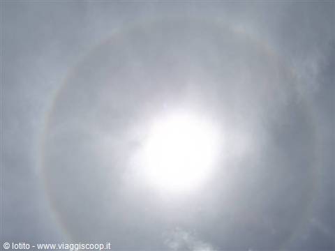  Circular solar halo among clouds, bright sun at the ring's center 