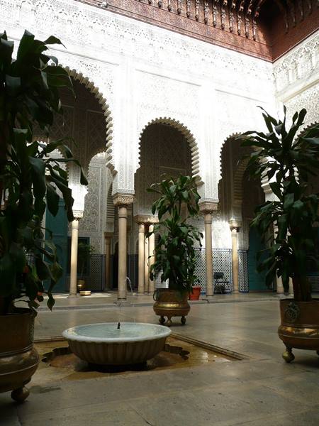 Bahia Palace courtyard in Marrakech with marble fountain, carved arches and plants