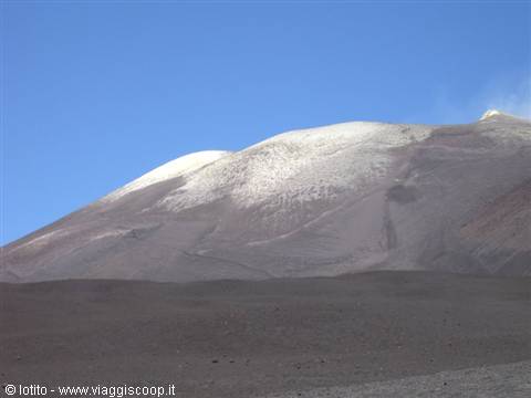 Snow-capped summit craters of Mount Etna above dark lava slopes