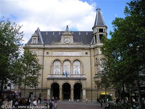The Brussels Stock Exchange, stone building with clock and tower, under clouds