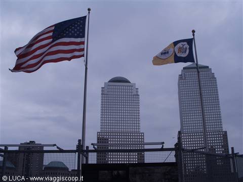 American flag and World Financial Center skyscrapers in New York under grey sky