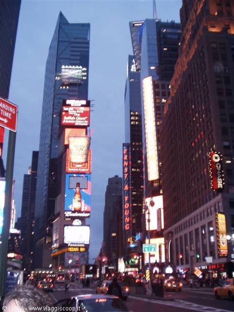 Times Square: skyscrapers with glowing billboards, yellow taxis at dusk