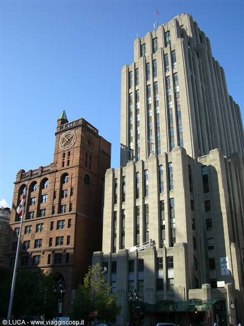 Art deco stone skyscraper beside brick clock tower building, Montreal