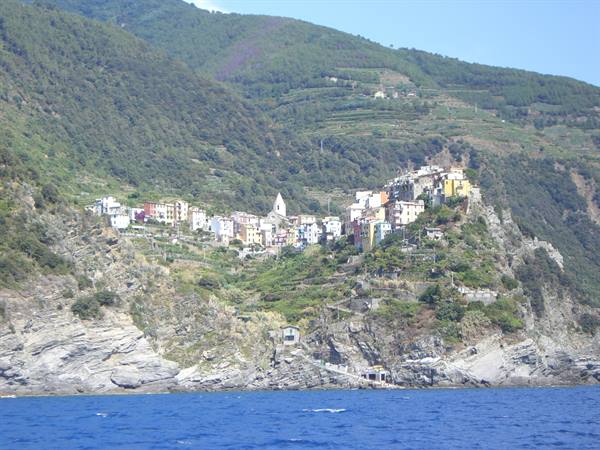 Corniglia seen from the sea, colorful houses among vineyards and cliffs