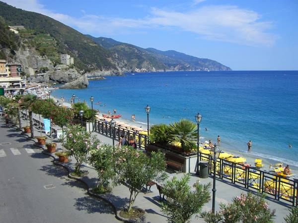 Flowered seaside promenade with bathers on the beach in Monterosso al Mare