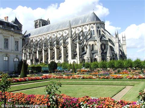 Bourges Cathedral in light stone among flowerbeds and green lawn
