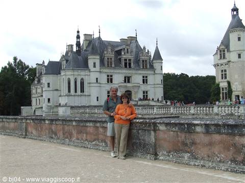 Tourist couple by the stone wall of Château de Chenonceau
