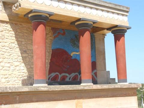 Red painted wooden columns and bull fresco at Knossos