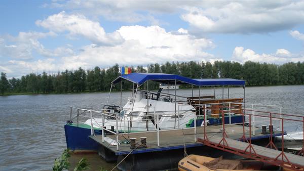 Boat with Romanian flag moored at a pier on the Danube