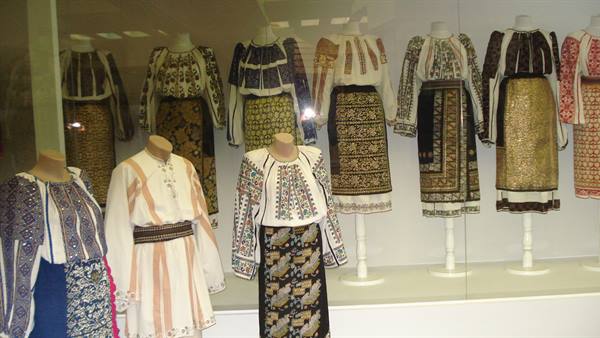 Traditional embroidered folk costumes displayed on mannequins in museum case