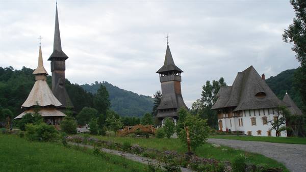 Bârsana wooden churches with tall spires among green meadows