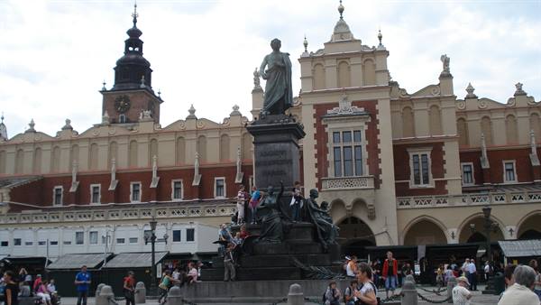 Tourists gathered around the Mickiewicz monument in front of the Cloth Hall, Kraków
