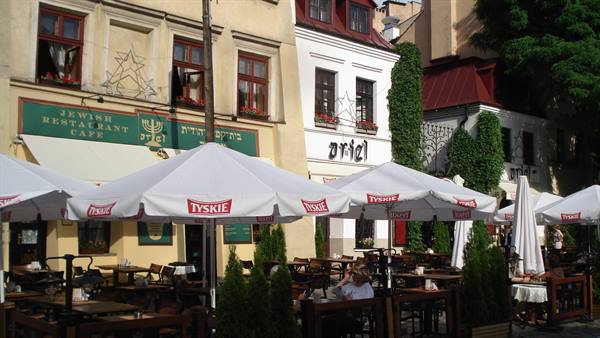 Ariel café in Kraków's Jewish quarter, white Tyskie umbrellas over outdoor tables