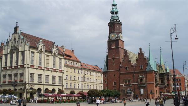 Gothic brick town hall with clock tower on a crowded square, Wrocław
