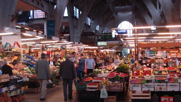 Busy Rialto market in Venice, fruit stalls beneath concrete vaults