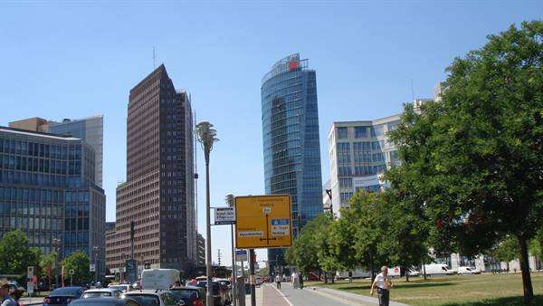 Potsdamer Platz in Berlin, glass towers, traffic and pedestrians under sunny sky